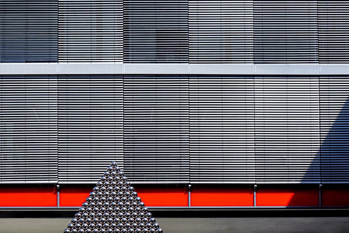 # 3700 Carbonadamas l Carbon Diamant Augsburg, Germany August 2021 Partial view of a metal pyramid casting a shadow on the facade in the courtyard of the computer center and library of the Augsburg University of Applied Sciences. Photo © Michael Nguyen/VG Bild-Kunst, Bonn